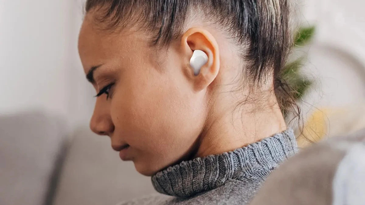 Usuária utilizando o fone intra-auricular Samsung Galaxy Buds Core branco demonstrando encaixe firme e discreto