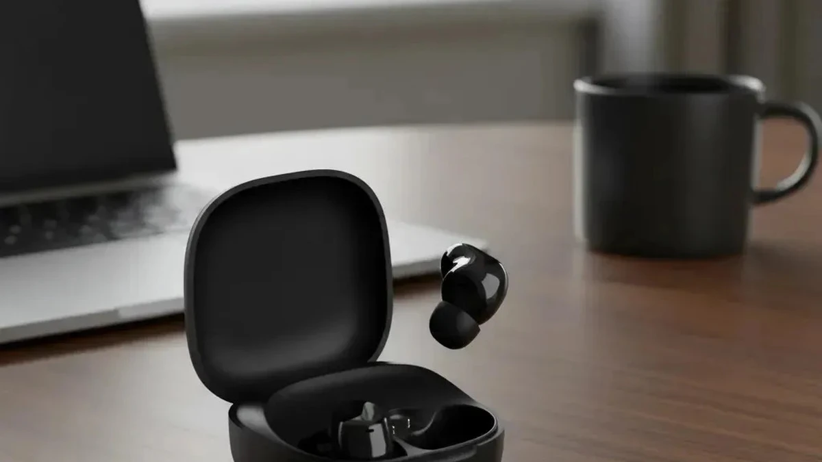 Estojo compacto e fone Xiaomi Redmi Buds 6 Play sobre a mesa de trabalho perto de notebook